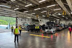 Workers load cars aboard the Columbia ferry during a stop in mid-July. (Meredith Jordan / Juneau Empire File)