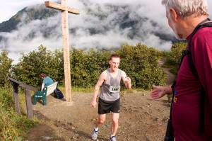 Shawn Miller hands his racing jersey tag to a volunteer after winning the Goldbelt Tram-Mount Roberts Run on Saturday with a time of 35 minutes, 52 seconds. (Mark Sabbatini / Juneau Empire)