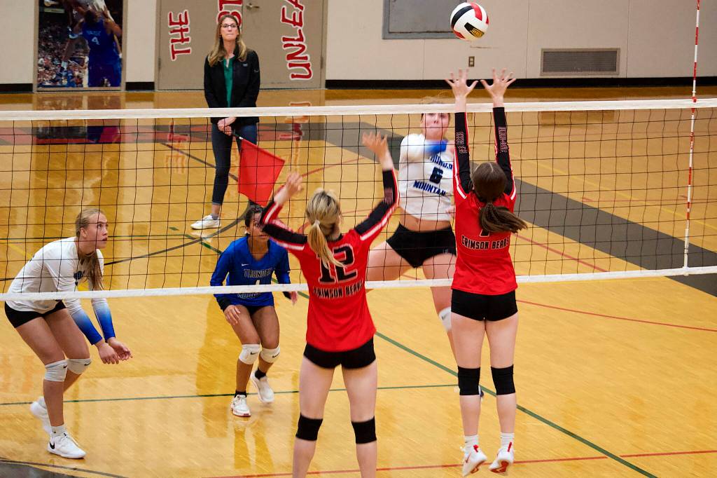 Thunder Mountain High Schools Jayden Rosenbruch (6) hits the ball past Evelyn Richards (12) and Gwen Nizich (6) of Juneau-Douglas High School: Yadaa.at Kalé during a game Saturday night at JDHS. (Mark Sabbatini / Juneau Empire)