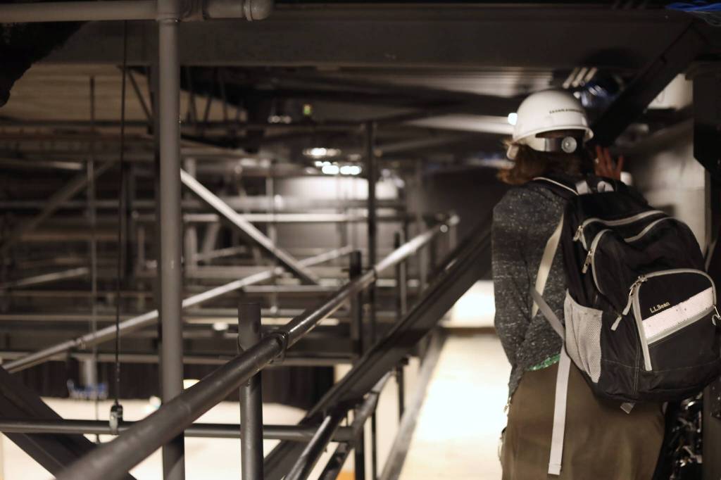 The project manager for the Centennial Hall ballroom renovation, Lisa Eagan-Lagerquist, walks the catwalk near the ceiling of the ballroom set to open its doors again for the first time on Saturday after nearly nine months under construction. (Clarise Larson / Juneau Empire)