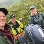 From left, Peter Haeussler, Gerry Hatcher and Drake Singleton carry a boat motor one-quarter mile to a lake they will study for signs of past earthquakes. (Photo by Peter Haeussler)
