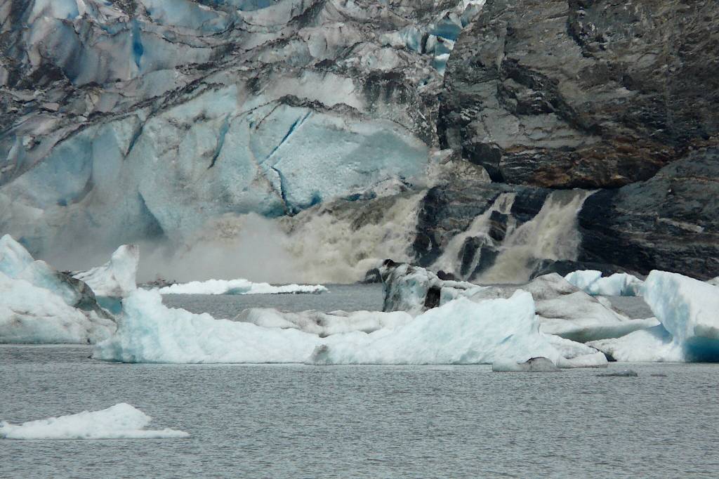 A sediment-laden grey waterfall gushes jokulhlaup water from under Mendenhall Glacier at 9:30 p.m. on July 20, 2011. (Photo by Laurie Craig)