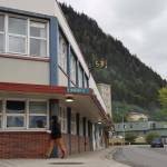 Cars and people move past the City and Borough of Juneaus current City Hall downtown on June 5. (Clarise Larson / Juneau Empire File)