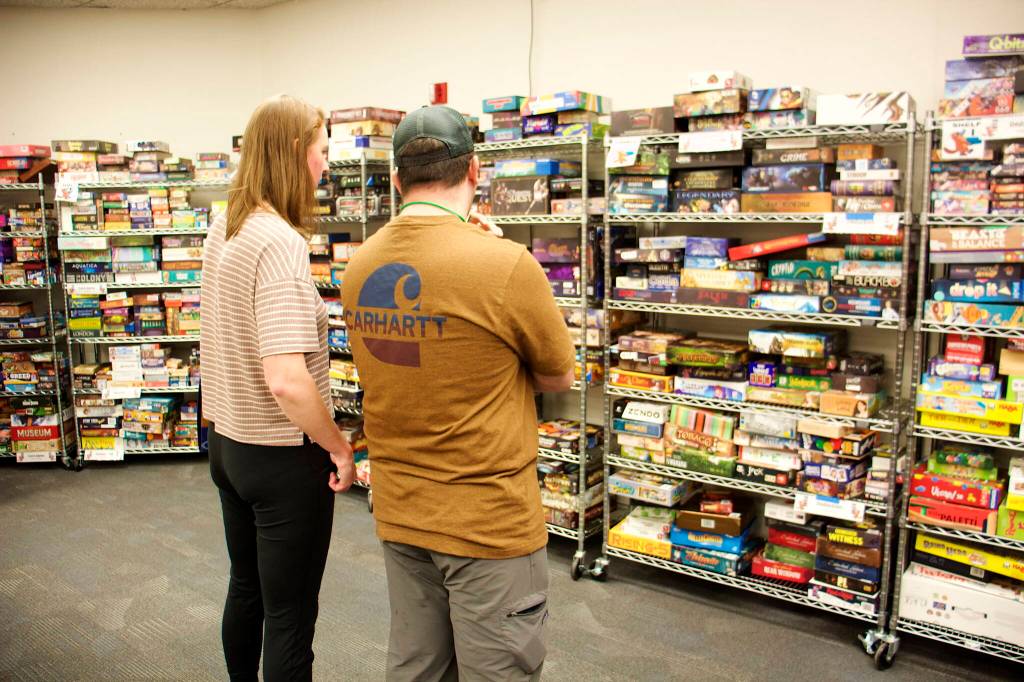 Jarred and Bekah Mitrea, visiting from Gustavus, look for worthy titles among the 2,200 in the library at the Platypus-Con Board and Card Game Extravaganza at Centennial Hall on Saturday. (Mark Sabbatini / Juneau Empire)