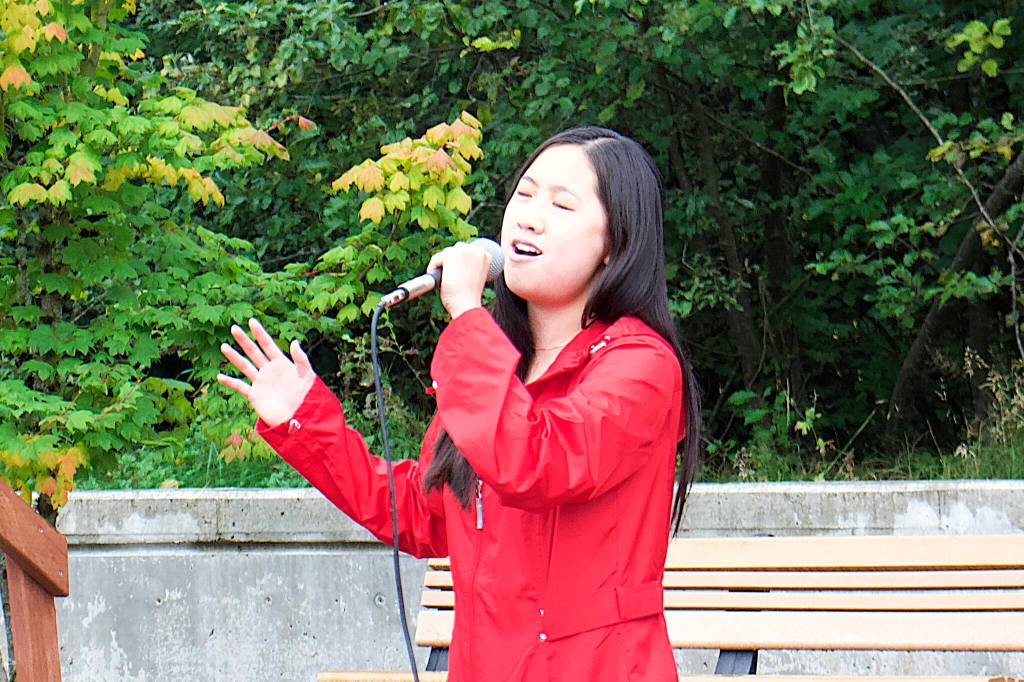 Elizabeth Djajalie sings the national anthem during a ceremony Monday at the September 11th Memorial at Riverside Rotary Park commemorating the terrorist attacks on that date in 2001. (Mark Sabbatini / Juneau Empire)