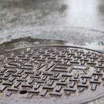 Rainwater surrounds a sewer maintenance hole in the Mendenhall Valley area Thursday afternoon. (Clarise Larson / Juneau Empire)