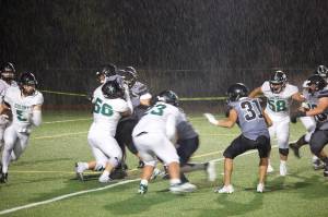 Colony High School running back Bryce Guzman (5) looks for room to run in a downpour during Friday nights game against the Juneau Huskies at Adair-Kennedy Field. (Mark Sabbatini / Juneau Empire)