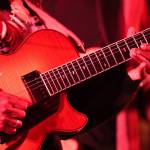 Albino Mbie, a musician from Mozambique, plays a solo on his guitar during a performance Thursday night as part of the Áakw Rock music festival at Elizabeth Peratrovich Hall. (Clarise Larson / Juneau Empire)
