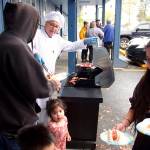 Larry Gamez, a board member of St. Vincent de Paul Juneau, cooks hot dogs for visitors at the organizations complex on Teal Street on Saturday as part of a Friends of the Poor Run/Walk to raise money for the facility and its programs. (Mark Sabbatini / Juneau Empire)