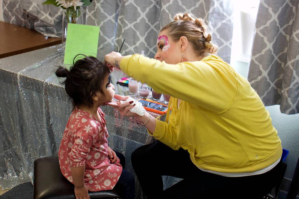 Angel White, 2, gets her face painted by Jennifer Skinner inside St. Vincent de Paul Juneaus Teal Street complex on Saturday as part of a Friends of the Poor Run/Walk to raise money for the facility and its programs. (Mark Sabbatini / Juneau Empire)