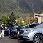 A rainbow appears over downtown as residents check out rows of electric vehicles at Juneaus EV & E-bike Roundup Saturday afternoon. (Clarise Larson / Juneau Empire)