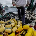 Darren Platt, left, captain of the Agnes Sabine, and first-year deckhand Juan Zuniga, right, step over nets as they dock the boat for refueling, Friday, June 23, 2023, in Kodiak, Alaska. Retaining deckhands is key for Platt and he says he focuses on keeping crew members as comfortable as possible so that they might return again to work the following season while teaching them the skills they need to perform their job on the boat. (AP Photo/Joshua A. Bickel)