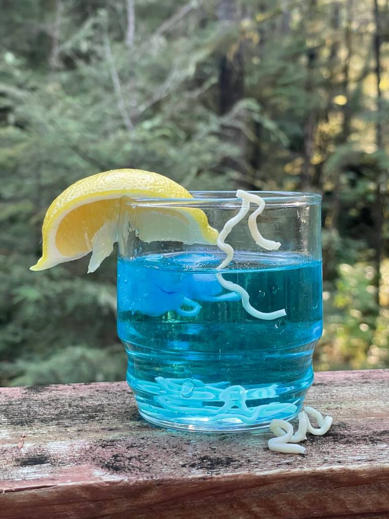 Commemorating Stroller Whites most famous column, the contributor created a mock Ice Worm Cocktail using blue food coloring in a glass of water with ramen noodles. The citrus slice celebrates one of newspaperman Whites enduring phrases to put a squirt of lemon in it. (Photo by Laurie Craig)