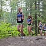 Girls from Thunder Mountain High School run on a trail in the Sayeik Invitational on Douglas on Aug. 26. Students from Southeast Alaska schools will participate at the same site Saturday for the Region V cross-country champions. (Clarise Larson / Juneau Empire File)