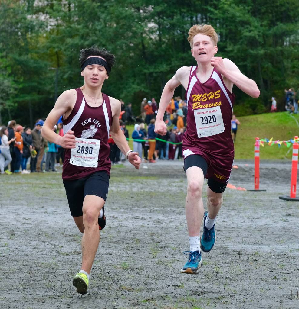 Ketchikan sophomore Carter Phillips and Mt. Edgecumbe senior Jacob Friske sprint to 17:59 finishes during the combined DI/DII Region V Boys Cross Country Championship on Saturday at Treadwell Mine Trails. (Klas Stolpe / For the Juneau Empire)