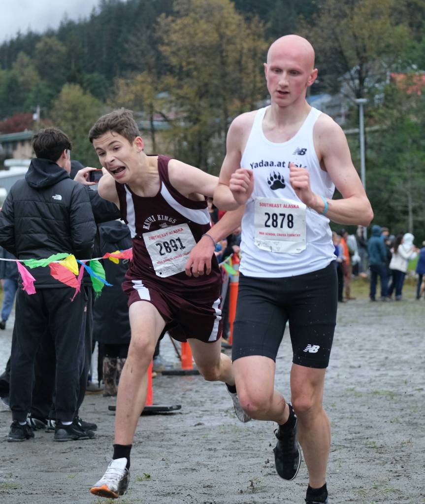 Ketchikan freshman Noah Robbins and Juneau-Douglas High School: Yadaa.at Kalé senior Malachi Peimann cross the finish with 17:48 times during the Division I Region V Boys Cross Country Championship race on Saturday at Treadwell Mine Trails. (Klas Stolpe / For the Juneau Empire)