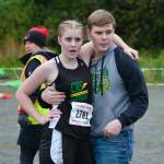 Craig High School freshman Ashlynn Smith is supported by brother Kyle Smith at the finish of the Division III Region V Girls Cross Country Championship race on Saturday at Treadwell Mine Trails. (Klas Stolpe / For the Juneau Empire)