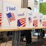 Residents sit in voter booths at the voter center located at the Mendenhall Valley Public Library on Tuesday afternoon. (Clarise Larson / Juneau Empire)