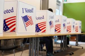 Residents sit in voter booths at the voter center located at the Mendenhall Valley Public Library on Tuesday afternoon. (Clarise Larson / Juneau Empire)