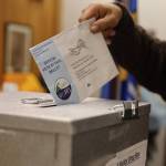Michael Beasley drops a ballot into a drop box at the City Hall Assembly Chambers on Election Day Tuesday morning. (Clarise Larson / Juneau Empire)
