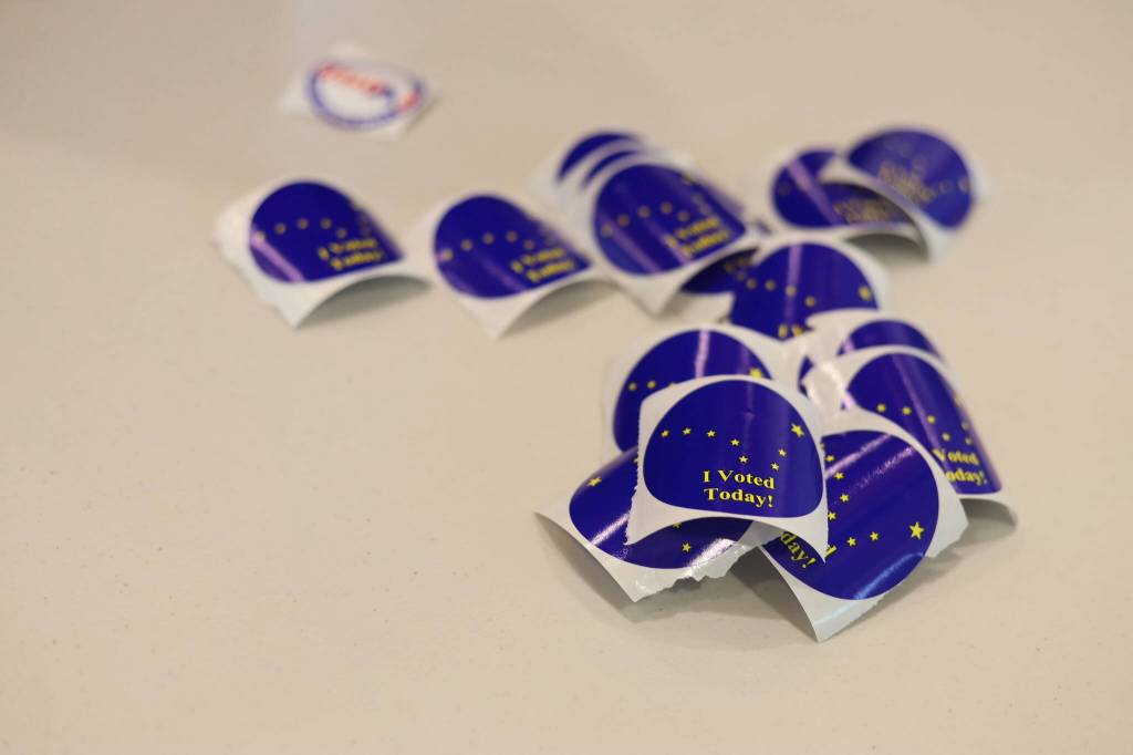 Stickers lay scattered on a table at the voter center located at the Mendenhall Valley Public Library on Tuesday afternoon. (Clarise Larson / Juneau Empire)
