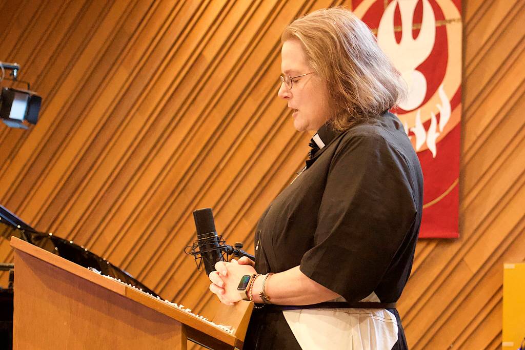 Resurrection Lutheran Church Pastor Karen Perkins offers an opening prayer before a lengthy discussion Sunday about whether the church is willing to again host a winter warming shelter. (Mark Sabbatini / Juneau Empire)