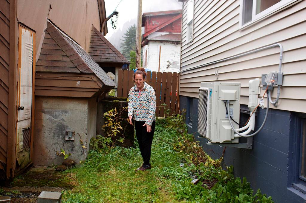 Becca Antonoplos shows the space between her house and Resurrection Lutheran Church on Sunday where she believes a fence should be built to protect her home from people staying at the churchs winter warming shelter. (Mark Sabbatini / Juneau Empire)