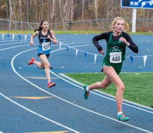 Colony High Schools Morgan Ainsworth sprints for the finish line against Chugiak High Schools Aaliyah Fields at the ASAA/First National Bank Alaska Cross Country State Running Championships in Palmer on Saturday. (Peter Pounds / Alaska Sports Report)