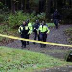 Juneau Police Department and Alaska State Troopers officials walk toward the Cope Park parking lot Monday afternoon. A death investigation is underway following the discovery of a body. (Clarise Larson / Juneau Empire)