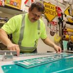 Chris Anderson measures a Heritage Way in preparation for the South Seward Street name change Nov. 1. (Clarise Larson / Juneau Empire)