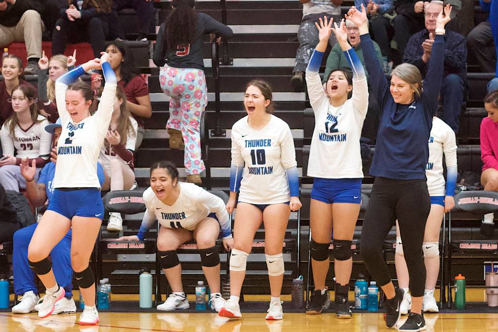 Thunder Mountain High School volleyball coach Julie Herman, right, celebrates with her players as they take a late lead over Chugiak High School in the second set of the championship game of the Juneau Invitational Volleyball Extravaganza at Juneau-Douglas High School: Yadaa.at Kalé on Saturday. (Mark Sabbatini / Juneau Empire)