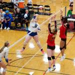 Thunder Mountain High Schools Kara Strong (16) knocks the ball past Juneau-Douglas High School: Yadaa.at Kalés Evelyn Richards (12) and Remi Starks (2) during the two local teams play-in game to reach the championship of the Juneau Invitational Volleyball Extravaganza at JDHS on Saturday. (Mark Sabbatini / Juneau Empire)