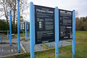 An exercise station at Anchorages Westchester Lagoon is seen on Monday. The Fitness Cluster offers opportunities for strength and cardiovacular training, and signage gives fitness information and advice. Two-thirds of Alaska adults are overweight or obese, and about a fifth of them engage in no physical activity, according to an annual report released by the state Department of Health. (Photo by Yereth Rosen/Alaska Beacon)