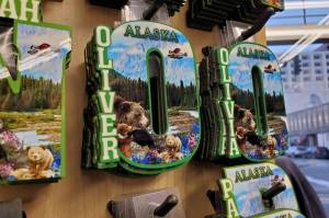 Alaska souvenirs bearing the names Oliver and Olivia are seen in a downtown Anchorage gift shop on Thursday. Oliver was the most popular name for baby boys in Alaska in 2022, and Olivia was one of the most popular names for baby girls. (Photo by Yereth Rosen/Alaska Beacon)