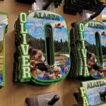 Alaska souvenirs bearing the names Oliver and Olivia are seen in a downtown Anchorage gift shop on Thursday. Oliver was the most popular name for baby boys in Alaska in 2022, and Olivia was one of the most popular names for baby girls. (Photo by Yereth Rosen/Alaska Beacon)