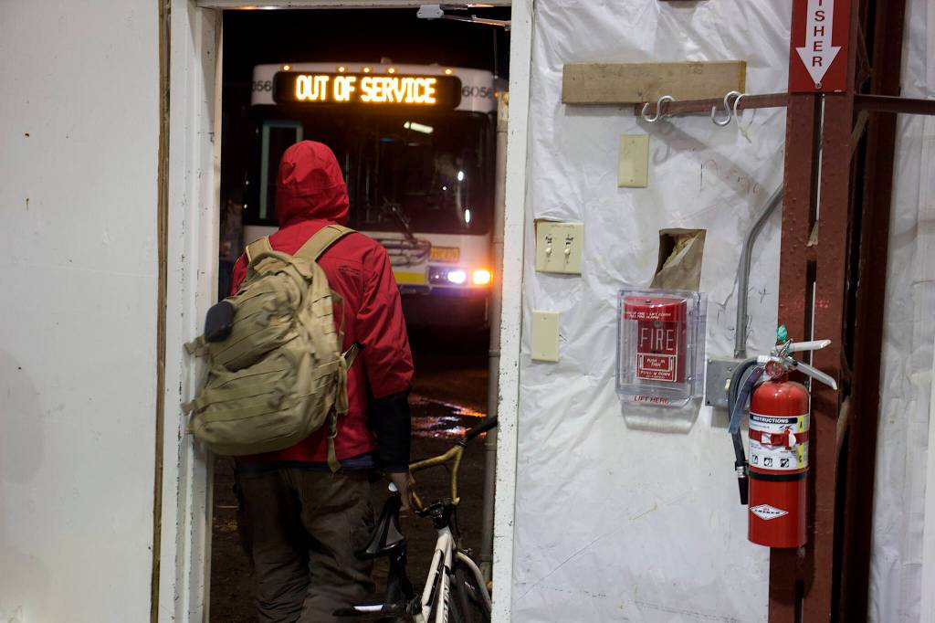 A person staying at the citys new cold weather emergency during its first night exits to board the bus taking shelter occupants elsewhere in town Saturday morning. (Mark Sabbatini / Juneau Empire)