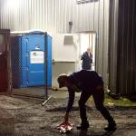Dave Ringle, executive director of St. Vincent de Paul Juneau, picks up an item dropped by a person arriving at the citys new cold weather emergency shelter on Friday night. SVDP is operating the shelter in a city-owned warehouse about a mile south of downtown Juneau. (Mark Sabbatini / Juneau Empire)