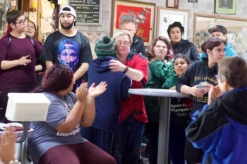 Jacob Mallinger, red shirt, embraces CJ Umbs after their four-person bowling team was among the three selected to advance to statewide competition following the Juneau Special Olympics local games at Pinz bowling ally Sunday. (Mark Sabbatini / Juneau Empire)