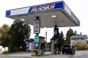 A passenger pumps gas into a vehicle Sunday at Fishermans Bend, which on that day had Juneaus lowest price for regular unleaded at just under $4 a gallon. (Mark Sabbatini / Juneau Empire)
