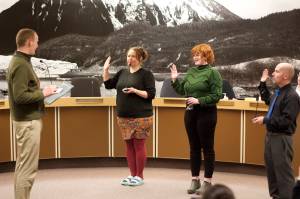 Juneau City and Borough Attorney Robert Palmer, left, swears in Assembly members Alicia Hughes-Skandijs, Ella Adkison and Paul Kelly on Monday night in the Assembly chambers. Adkison and Kelly are new members of the Assembly after winning open seats in the Oct. 3 municipal election, while incumbents Hughes-Skandijs and Christine Woll  who was sworn in remotely via Zoom at the same time  were reelected to their seats. (Mark Sabbatini / Juneau Empire)