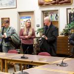 Newly-sworn Juneau Board of Education members Britteny Cioni-Haywood and David Noon (left) prepare to take their seats as outgoing members Brian Holst and Martin Stepetin Sr. (right) depart during the boards meeting Tuesday night at Juneau-Douglas High School: Yadaa.at Kalé. At center, Jessica Richmond, administrative assistant to the Juneau School District superintendent, replaces the name signs of the board members at the two seats. (Mark Sabbatini / Juneau Empire)