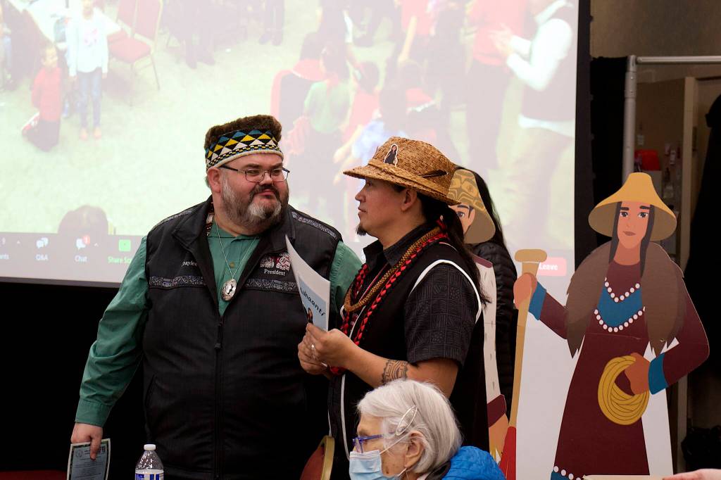 Richard Chalyee Éesh Peterson (left), president of the Central Council of Tlingit and Haida Indian Tribes of Alaska, discusses the release of the Lingít-language book Kuhaantí with X̱ʼunei Lance Twitchell, a language professor at the University of Alaska Southeast involved with its collaborative writing process, during the books release party Friday night at Elizabeth Peratrovich Hall. (Mark Sabbatini / Juneau Empire)