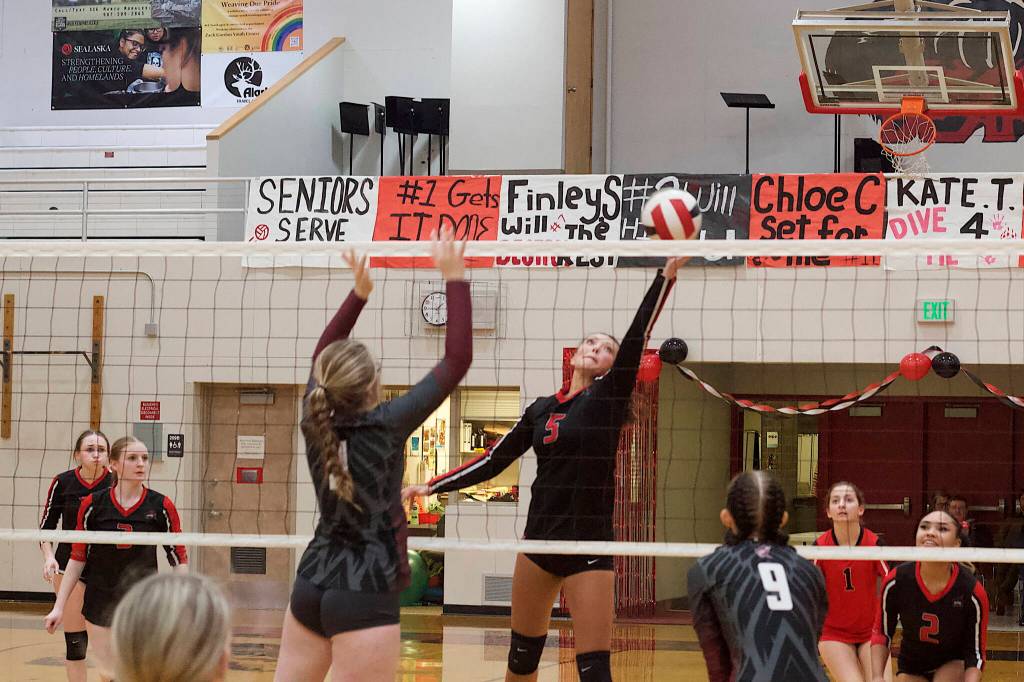 Kiah Yadao, one of the seniors on Juneau-Douglas High School: Yadaa.at Kalés varsity volleyball team, tries to get the ball past a Ketchikan High School player on Saturday night at JDHS. (Mark Sabbatini / Juneau Empire)