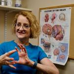 Patty Raymond-Turner, a coordinator for the Brain Injury Council of Alaska, demonstrates what happens to the brain when it is injured, on Sept. 26 in Anchorage. (Photo by Claire Stremple/Alaska Beacon)