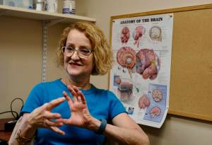 Patty Raymond-Turner, a coordinator for the Brain Injury Council of Alaska, demonstrates what happens to the brain when it is injured, on Sept. 26 in Anchorage. (Photo by Claire Stremple/Alaska Beacon)
