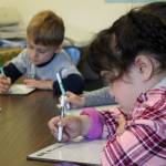 Students practice writing the letter M during a group activity led by Mountain View Elementary School Interventionist Katie Schneider on Thursday, Oct. 19, 2023, in Kenai, Alaska. (Ashlyn OHara/Peninsula Clarion)