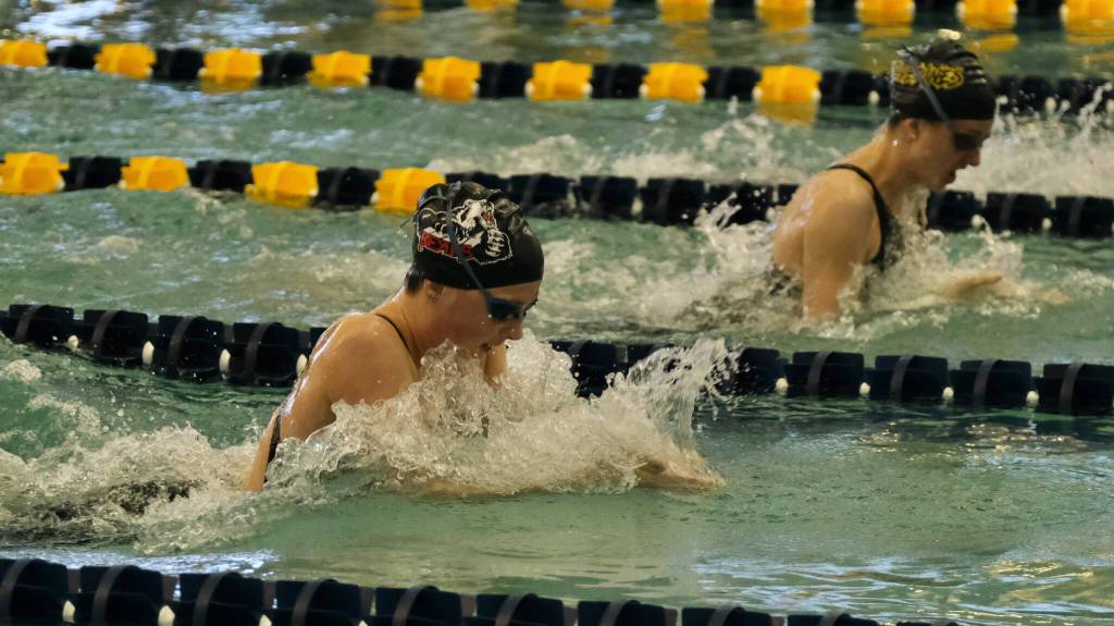 Juneau-Douglas High School: Yadaa.at Kalé junior Emma Fellman swims the breaststroke leg of the Crimson Bears winning 200-yard medley relay against Eagle River senior Maya Solomonson during the ASAA State Swim & Dive Championships on Saturday at the Dimond Park Aquatic Center. (Klas Stolpe / For the Juneau Empire)