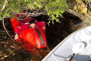 High tides make getting the skiff loaded a little tricky. The authors wife avoids low branches on her way to the skiff after a successful hunt. (Photo by Jeff Lund)