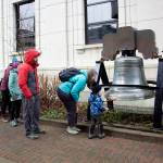 People line up to ring the Liberty Bell replica in front of the Alaska State Capitol at 11 a.m. Saturday during an Armistice Day observation hosted by Juneau Veterans for Peace. (Mark Sabbatini / Juneau Empire)