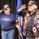 John Phillips (left) and Roger Sheakley salute the colors during the opening of the Southeast Alaska Native Veterans observance of Veterans Day on Saturday at Elizabeth Peratrovich Hall. (Mark Sabbatini / Juneau Empire)